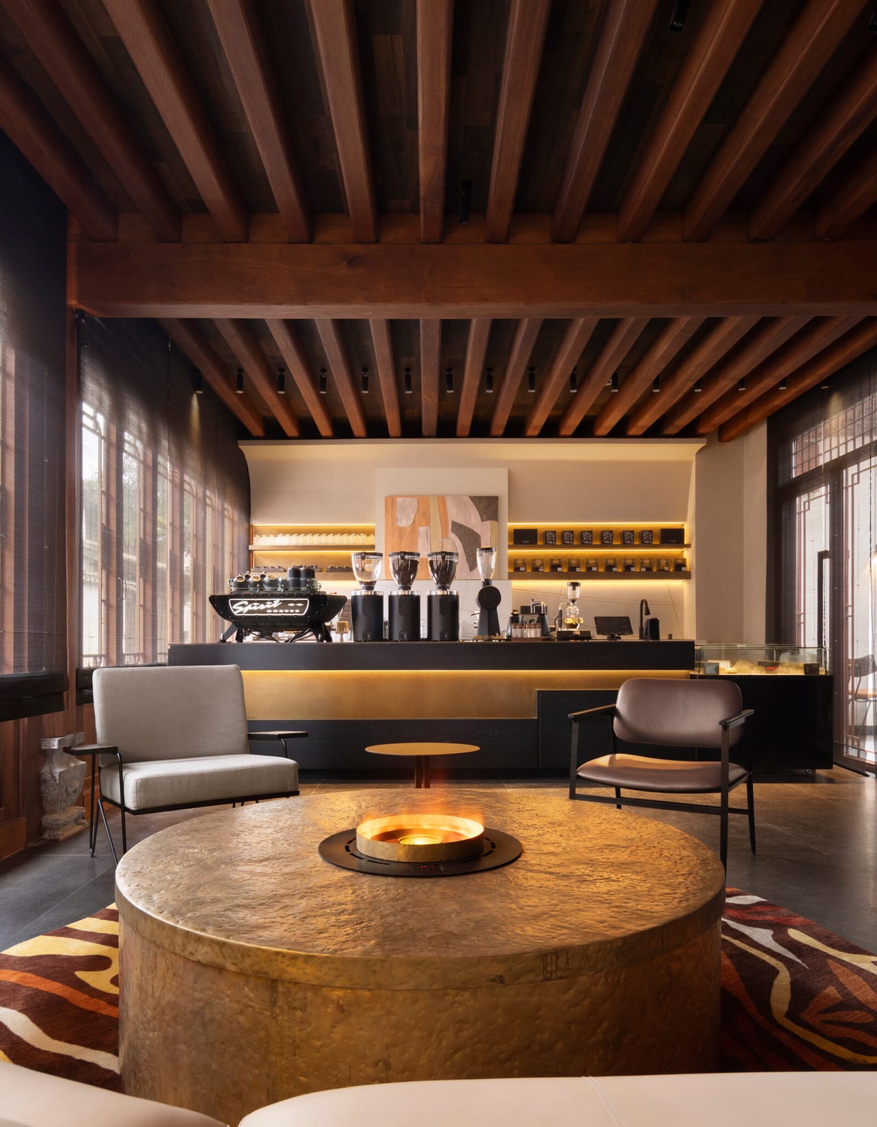 Kogongdi — the coffee-bar lounge set around a sunken brass fire pit under deep timber beams