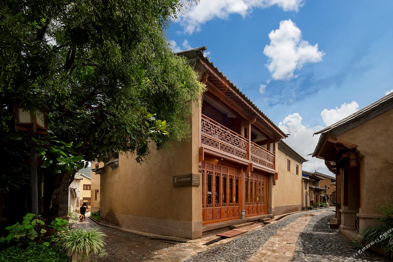 Kogongdi — the ochre rammed-earth facade and carved timber balcony on Beiguzong Lane, Shaxi Ancient Town