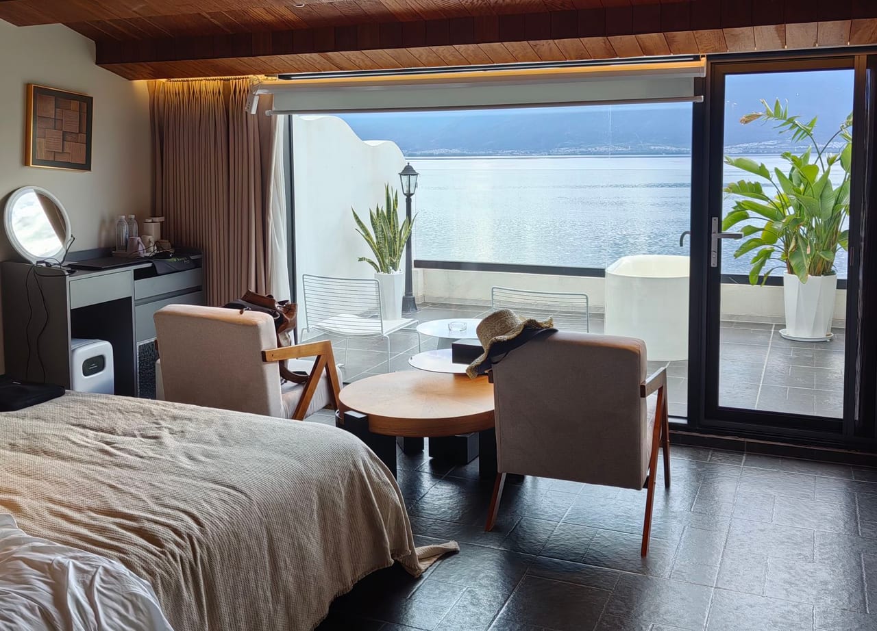 Suqi Lanting — guest room opening through glass doors onto Erhai Lake