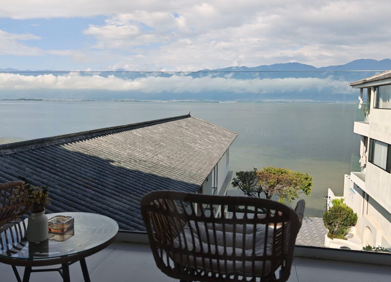 Suqi Lanting — terrace chairs set above the water, Erhai and Cang Mountain beyond