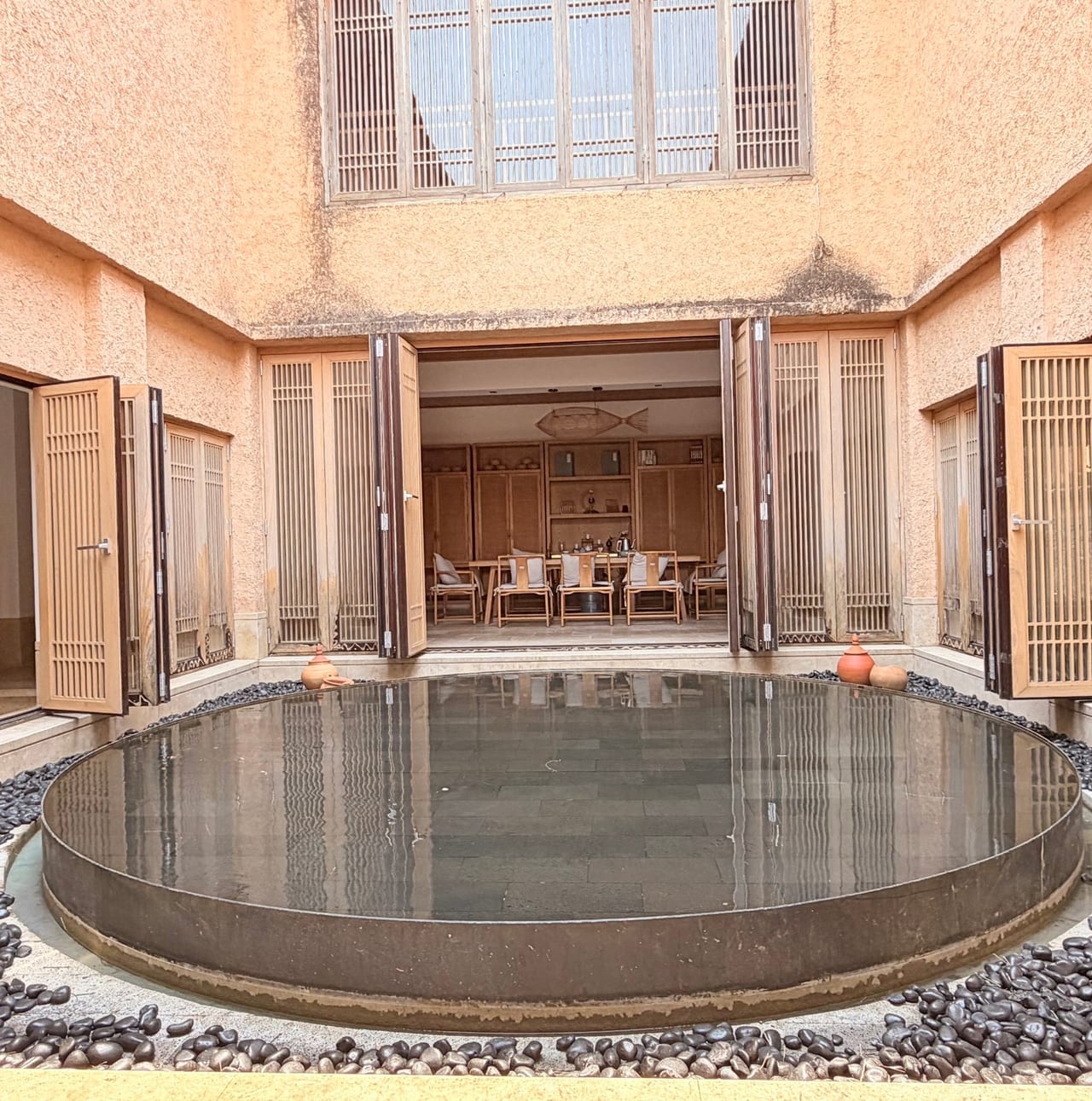 Oness Resort — the circular pool court behind folding timber screens
