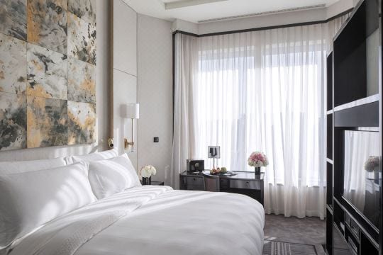The Peninsula Beijing — the upstairs bedroom of a Duplex Suite, a king bed beneath a marbled art panel