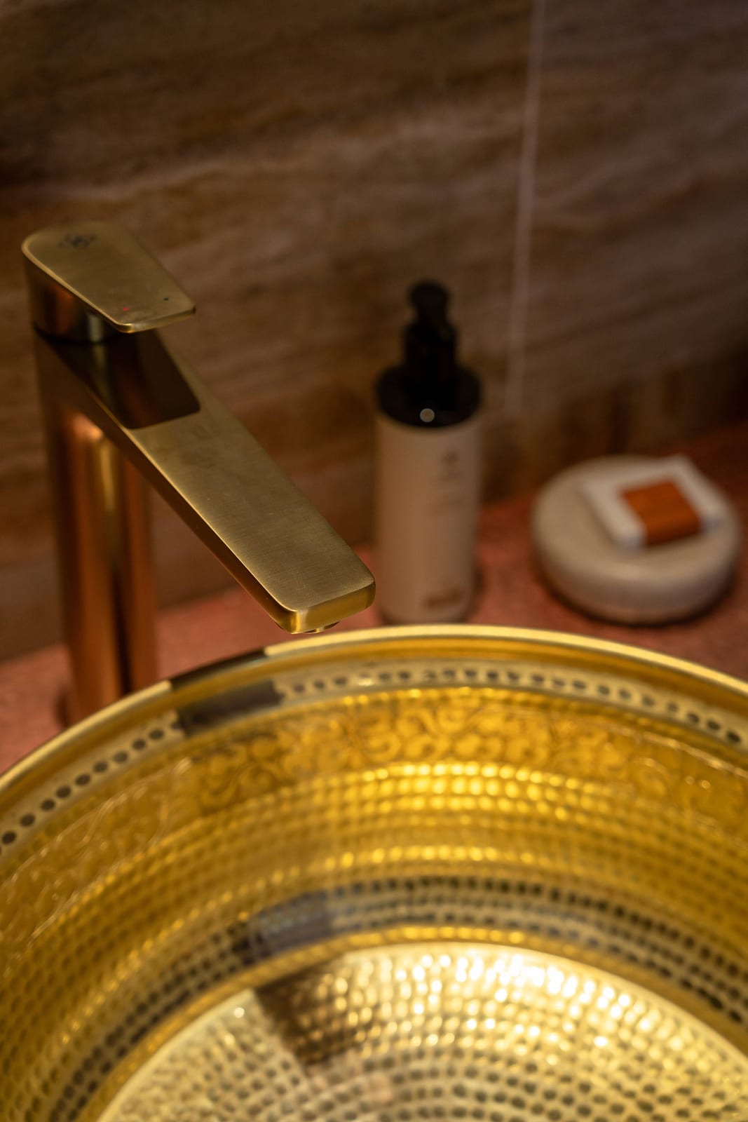 Songtsam Lodge Cizhong — a hammered-brass basin with a brass tap and bath oils