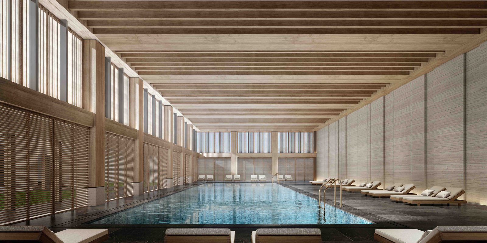 Heated indoor pool under a timber-beamed roof with clerestory windows and a row of loungers.