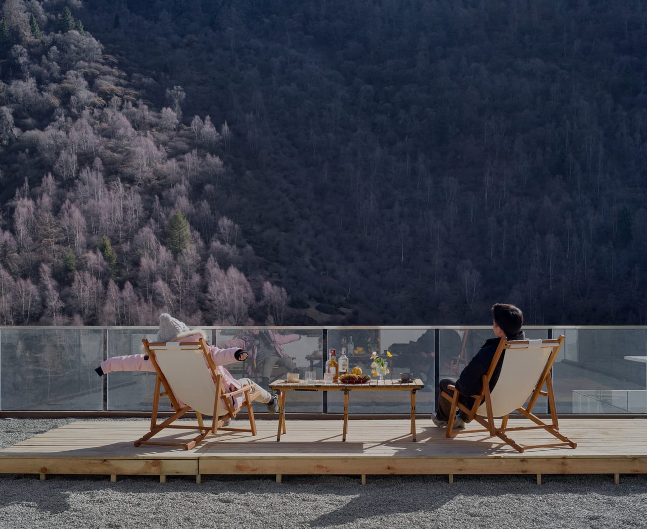 Vacilando Siguniang — deck chairs on the terrace above a snow-dusted forest slope in winter