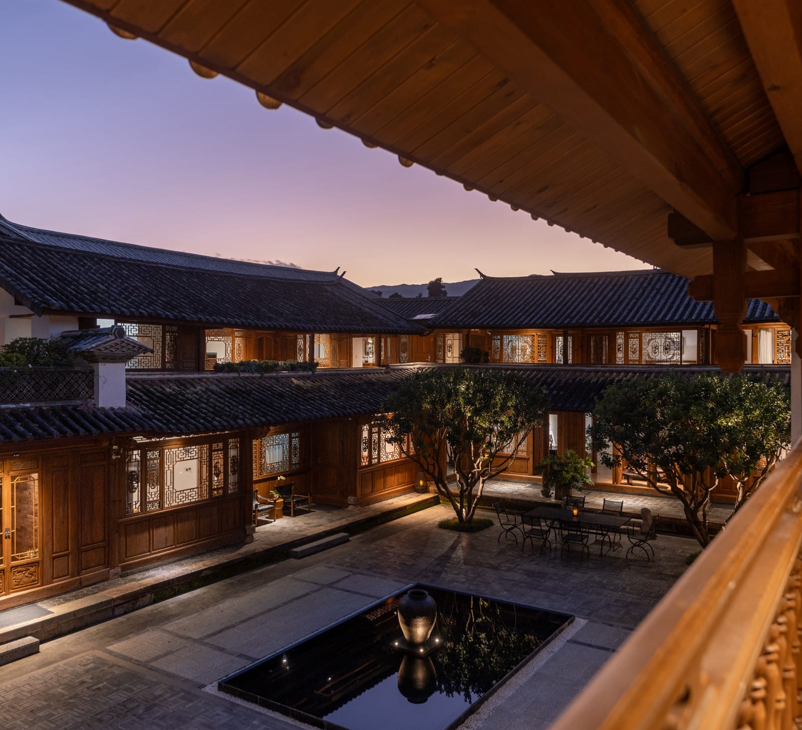 Wuliu Xinsu — the courtyard and grey-tiled roofs seen from the upper gallery at dusk