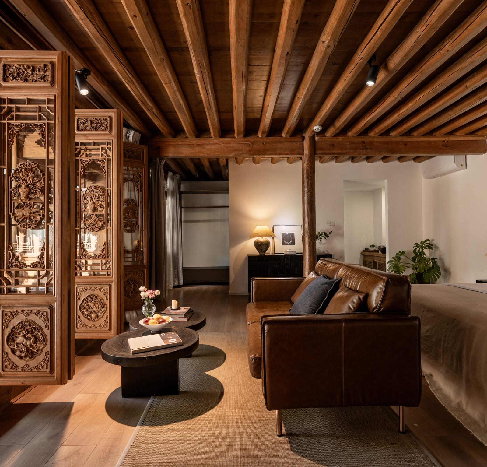 Wuliu Xinsu — the 65 m² courtyard suite, carved screens between the sitting area and the bed