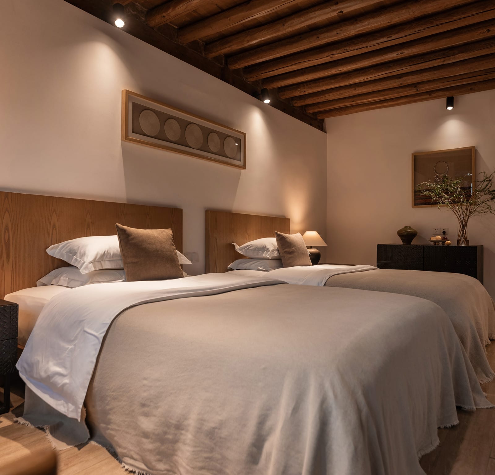 Wuliu Xinsu — a twin room with two beds and a timber-beamed ceiling