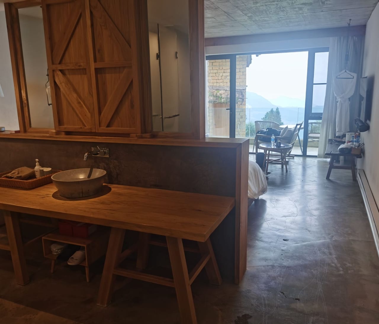 Yuanshe Azheke — the dining room, timber table set against the valley window