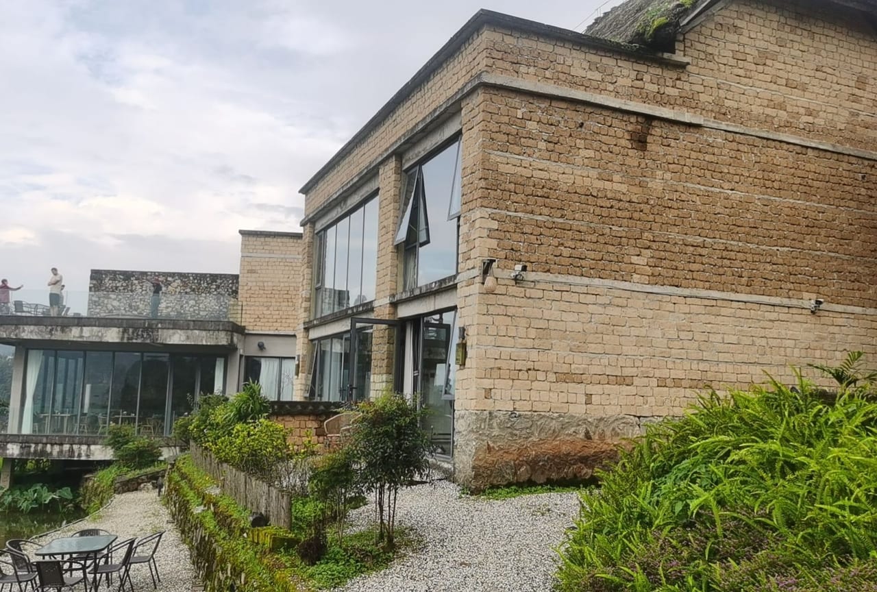 Yuanshe Azheke — the rammed-earth lodge sitting into the village edge