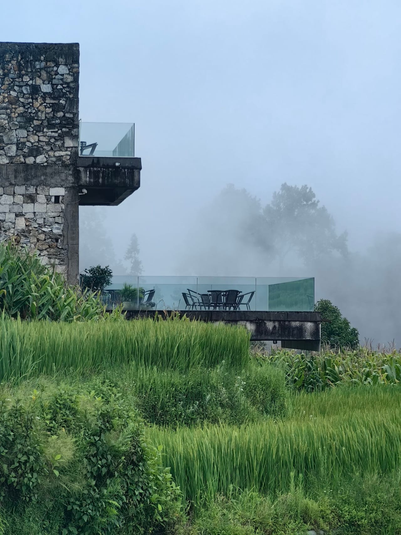 Yuanshe Azheke — the stone tower and its glass balcony over the terraces in mist