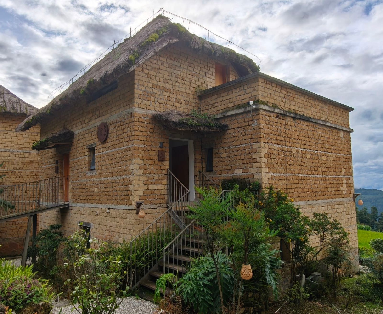 Yuanshe Azheke — a rammed-earth Hani mushroom house under thatch