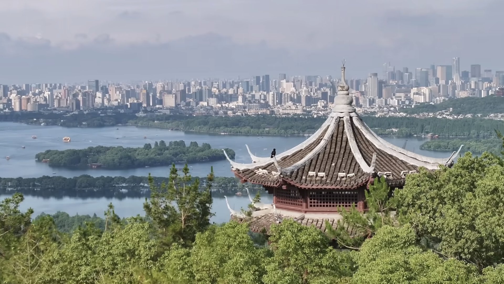 West Lake and the Hangzhou skyline beyond a pavilion roof