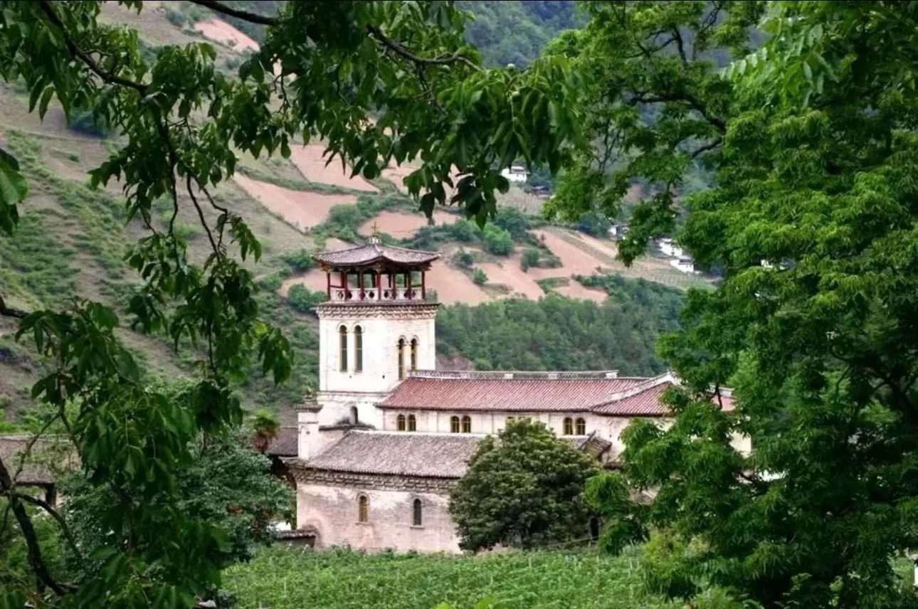 Cizhong: the mission church tower above the village roofs and terraced fields