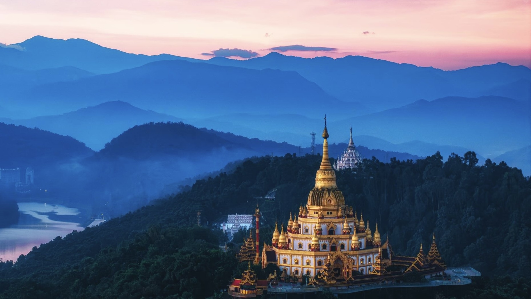 Golden and white pagodas above the Dehong valley at dusk